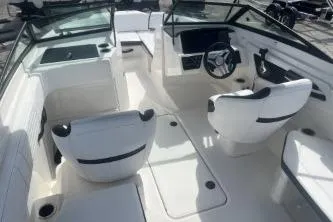 Slide: The Image of 2023 Sea Ray SPX 210 Outboard boat interior with white seating and steering console. - 7