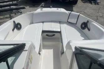 Slide: The Image of 2023 Sea Ray SPX 210 Outboard boat interior with white seating and speakers. - 9
