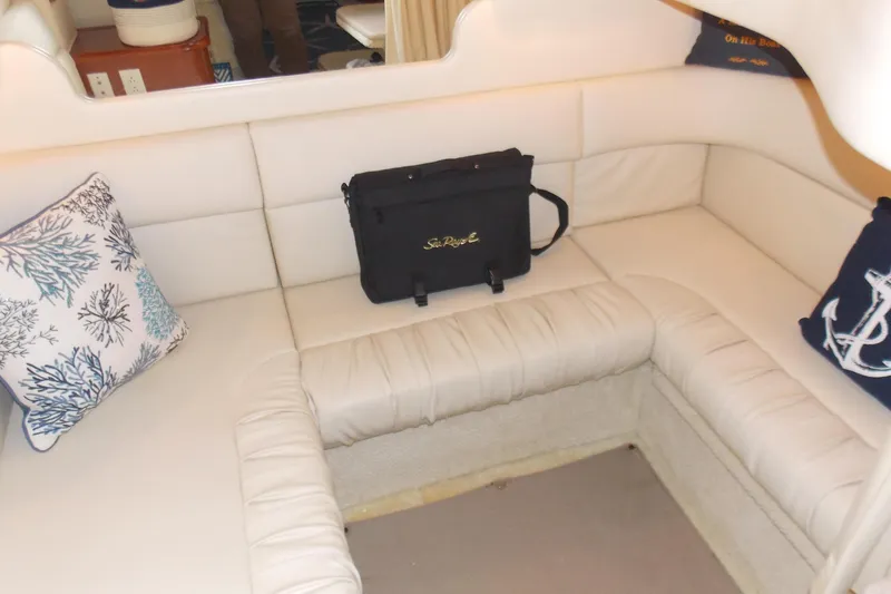 Slide: The Image of Interior of 2002 Sea Ray 340 Sundancer with white seating and nautical-themed pillows. - 10