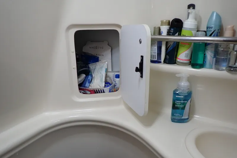 Slide: The Image of Bathroom storage on 2002 Sea Ray 340 Sundancer, featuring toiletries and hygiene products. - 102
