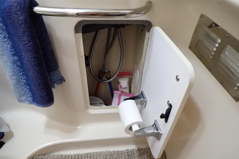 Slide: The Image of Storage compartment in 2002 Sea Ray 340 Sundancer boat bathroom with towel and toiletries. - 104