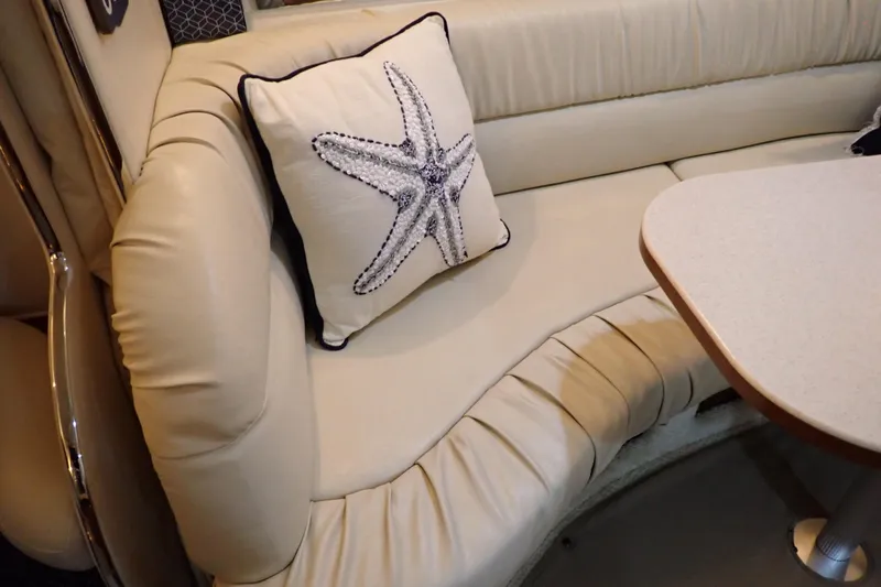 Slide: The Image of 2002 Sea Ray 340 Sundancer interior with cream leather seating and starfish pillow. - 107