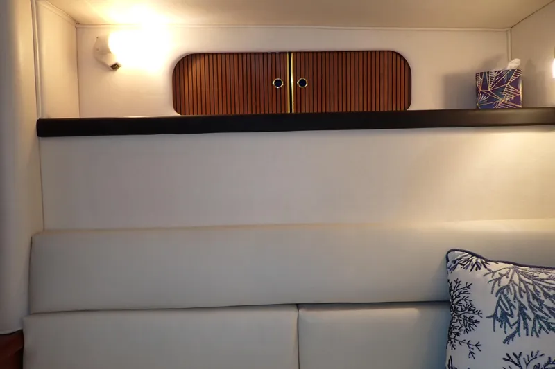 Slide: The Image of Interior of 2002 Sea Ray 340 Sundancer with cushioned seating and decorative pillow. - 111