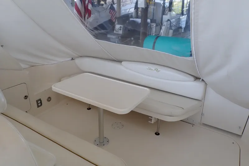 Slide: The Image of 2002 Sea Ray 340 Sundancer interior with seating and table, featuring a sleek, white design. - 13