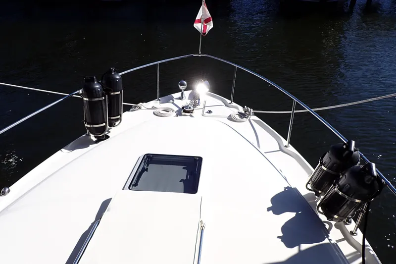 Slide: The Image of Bow view of 2002 Sea Ray 340 Sundancer yacht with railings and water backdrop. - 17