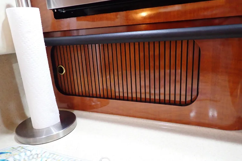 Slide: The Image of Interior of 2002 Sea Ray 340 Sundancer with wooden cabinetry and paper towel holder. - 77