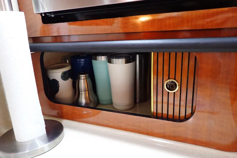 Slide: The Image of Storage area with cups and paper towel holder on 2002 Sea Ray 340 Sundancer yacht. - 78