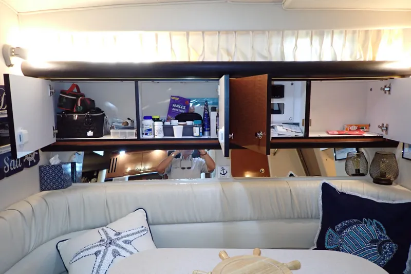 Slide: The Image of Interior of 2002 Sea Ray 340 Sundancer with open cabinets and nautical-themed decor. - 95