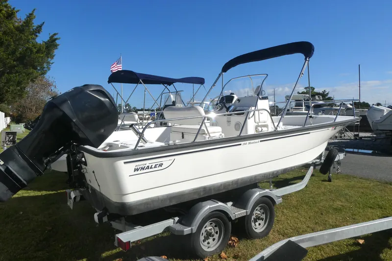 Slide: The Image of 2010 Boston Whaler 190 Montauk boat on trailer, with outboard motor and canopy. - 1