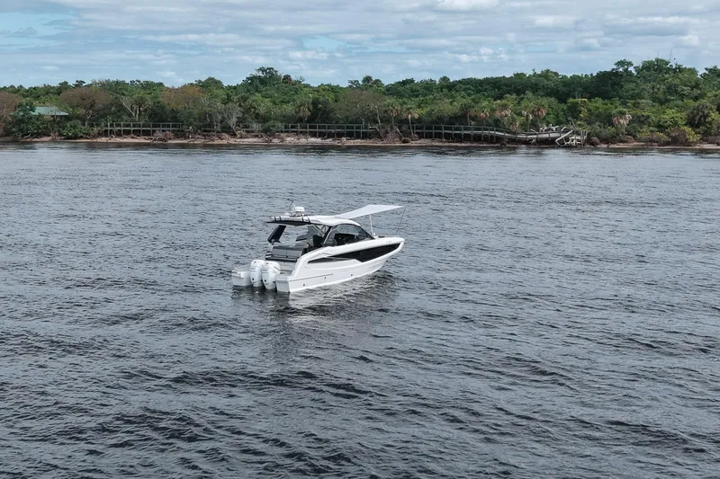 Slide: The Image of 2023 Galeon 400 XL yacht cruising on a serene river with lush green shoreline. - 46