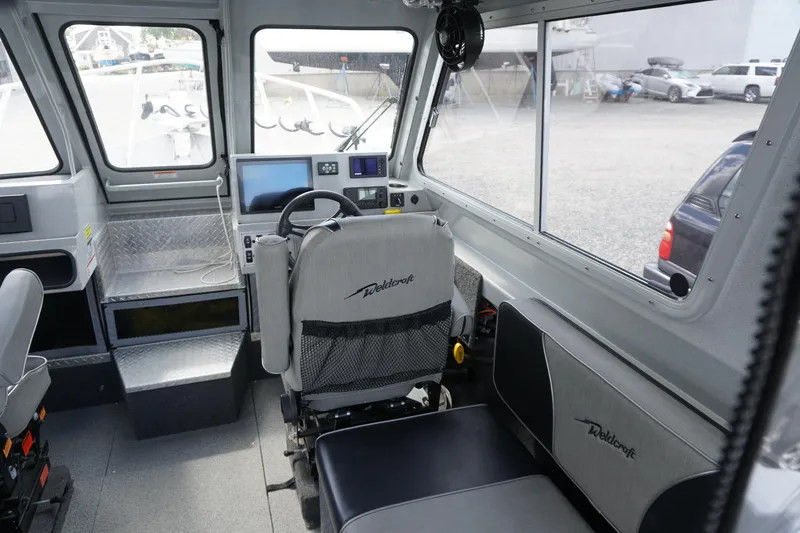 Slide: The Image of Interior of 2023 Weldcraft 220 Ocean King boat with modern controls and seating. - 13