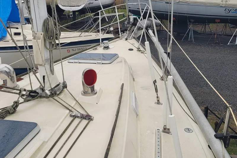 Slide: The Image of 1986 Sabre 34 sailboat deck with rigging and hatches, docked in a boatyard. - 11