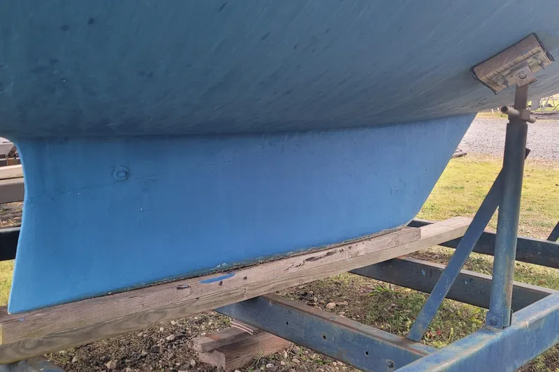 Slide: The Image of 1986 Sabre 34 sailboat keel on a trailer, blue hull, outdoor setting. - 19