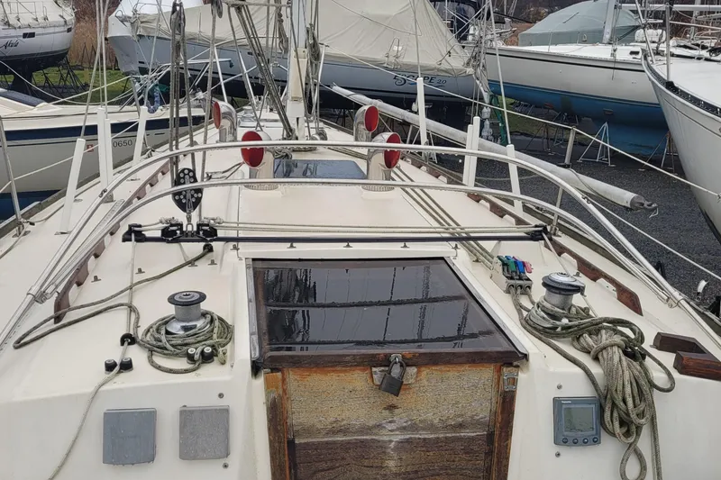 Slide: The Image of 1986 Sabre 34 sailboat deck with winches and ropes, docked among other boats. - 20