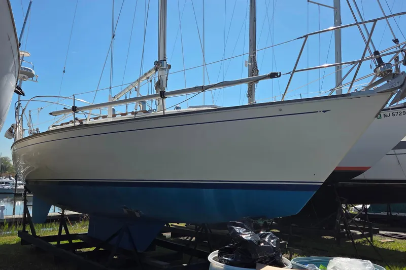 Slide: The Image of 1986 Sabre 34 sailboat on dry dock, blue hull, marina background. - 29