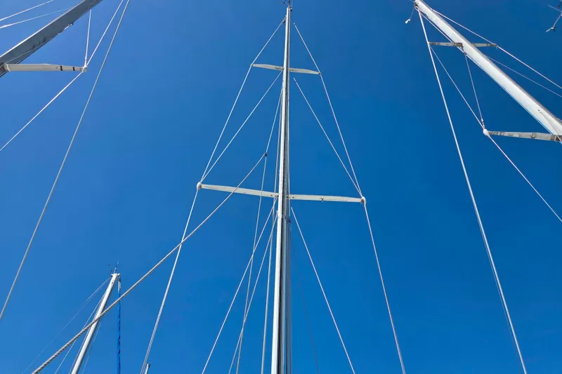 Slide: The Image of Tall masts of a 1986 Sabre 34 sailboat against a clear blue sky. - 37