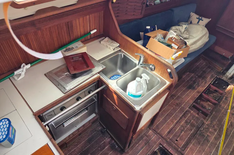 Slide: The Image of Interior of 1986 Sabre 34 sailboat galley with sink, stove, and wooden cabinetry. - 40