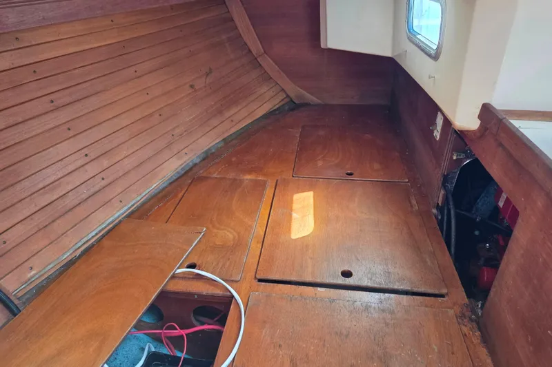 Slide: The Image of Interior of a 1986 Sabre 34 sailboat with wooden flooring and storage compartments. - 42