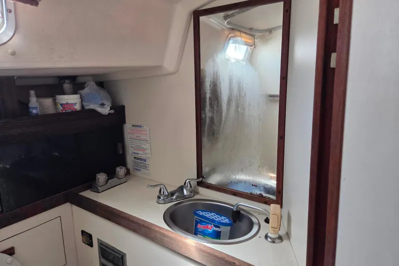 Slide: The Image of 1986 Sabre 34 yacht bathroom with sink, mirror, and storage shelves. - 47