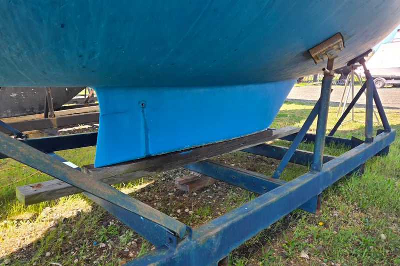 Slide: The Image of 1986 Sabre 34 sailboat hull on a metal stand, displayed outdoors. - 52