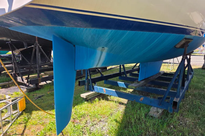 Slide: The Image of 1986 Sabre 34 sailboat hull on a stand, showcasing blue keel and rudder. - 53