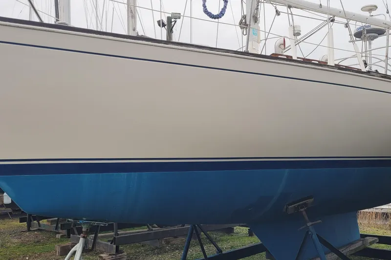 Slide: The Image of 1986 Sabre 34 sailboat on stands, showcasing its sleek hull design. - 6