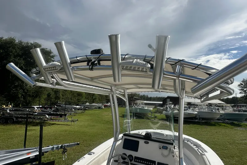 Slide: The Image of 2023 Sea Fox 228 Commander boat with T-top and rod holders, parked outdoors. - 11