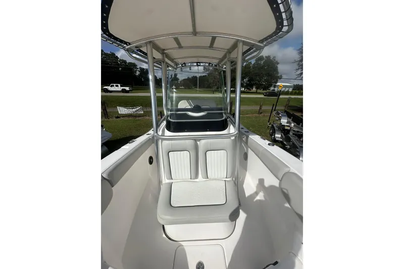 Slide: The Image of 2023 Sea Fox 228 Commander boat interior with seating and T-top, parked outdoors. - 18
