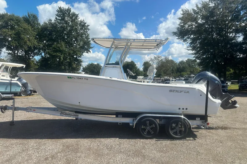 Slide: The Image of 2023 Sea Fox 228 Commander boat on trailer, parked outdoors under a blue sky. - 25
