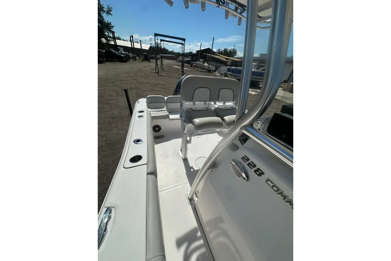 Slide: The Image of 2023 Sea Fox 228 Commander boat interior with seating and console, parked outdoors. - 41