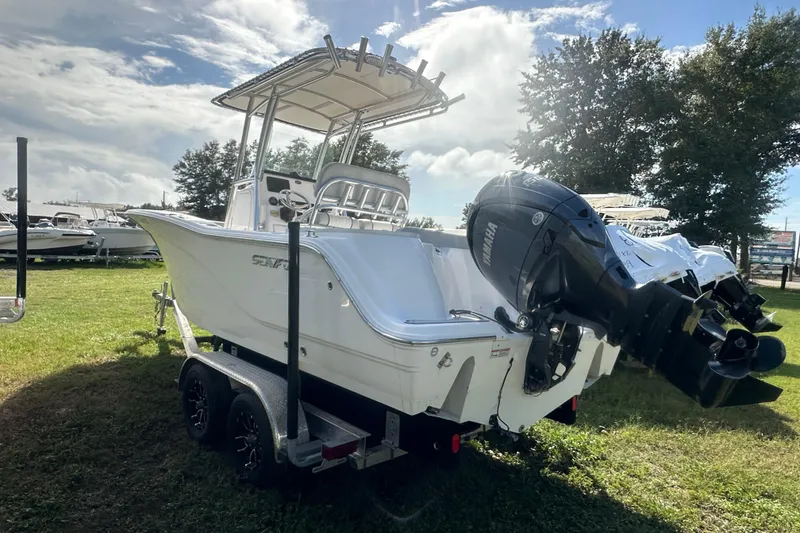 Slide: The Image of 2023 Sea Fox 228 Commander boat on trailer, parked on grass under a cloudy sky. - 5