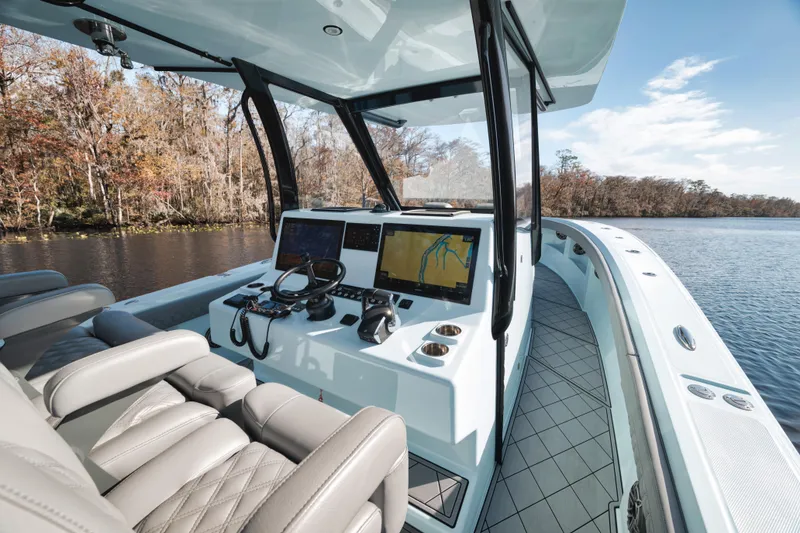 Slide: The Image of 2026 Front Runner 39' Center Console boat interior with advanced navigation system on a serene lake. - 17