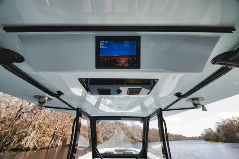 Slide: The Image of 2026 Front Runner 39' Center Console boat interior with digital display, cruising on a scenic river. - 18