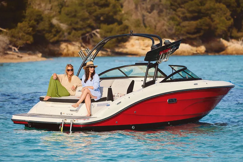 Slide: The Image of Manufacturer Provided Image: 2025 Sea Ray SPX 210 boat on clear blue water with two people relaxing. - 11