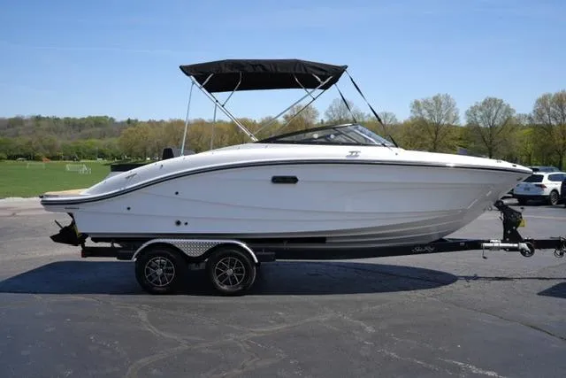 Slide: The Image of 2026 Sea Ray SPX 210 boat on trailer, parked outdoors under clear sky. - 21