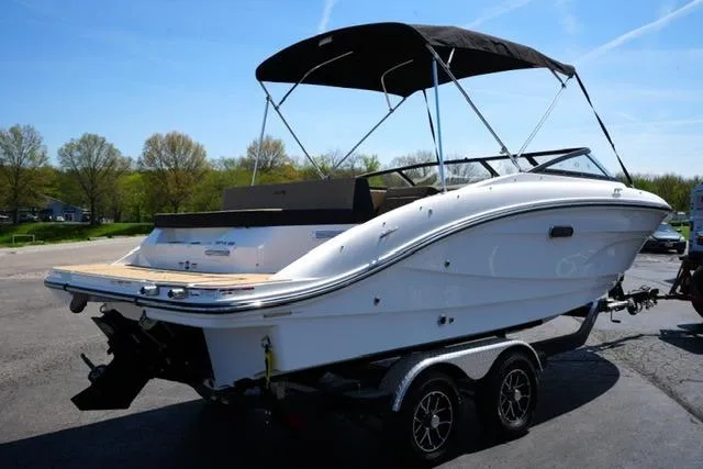Slide: The Image of 2026 Sea Ray SPX 210 boat on trailer, parked outdoors under clear sky. - 22