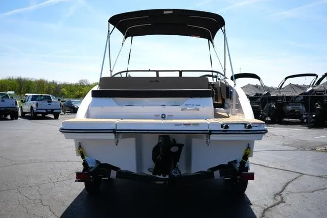 Slide: The Image of 2026 Sea Ray SPX 210 boat, rear view, parked on a trailer in a sunny lot. - 23