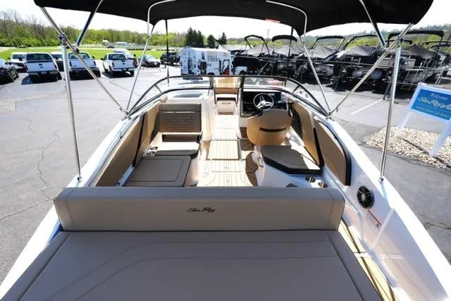 Slide: The Image of 2026 Sea Ray SPX 210 boat interior with seating and steering wheel, parked outdoors. - 25