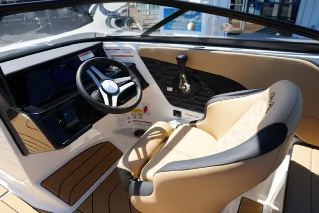 Slide: The Image of 2026 Sea Ray SPX 210 boat interior with steering wheel and beige seating. - 30