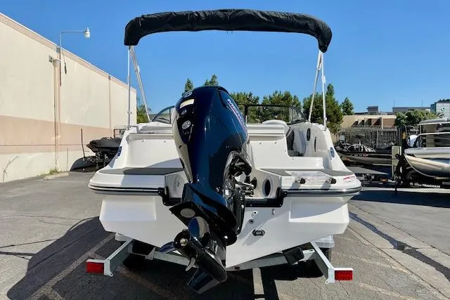 Slide: The Image of 2025 Bayliner V20 boat with outboard motor, parked on a trailer in a sunny lot. - 17