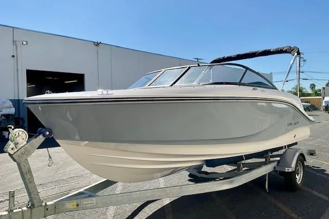 Slide: The Image of 2025 Bayliner V20 boat on trailer, parked outdoors, under clear blue sky. - 15