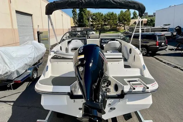Slide: The Image of 2025 Bayliner V20 boat with outboard motor, parked outdoors. - 3