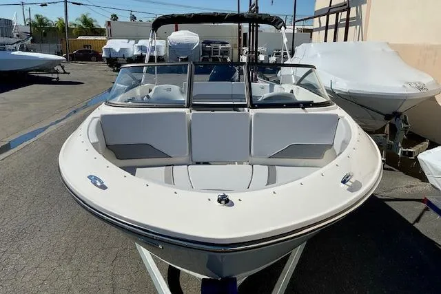 Slide: The Image of 2025 Bayliner V20 boat with sleek design, parked outdoors in a marina setting. - 4