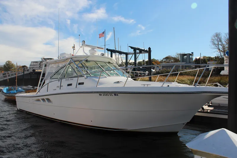 The Image of 2005 Rampage 38 Express boat docked at marina under clear blue sky. - 0