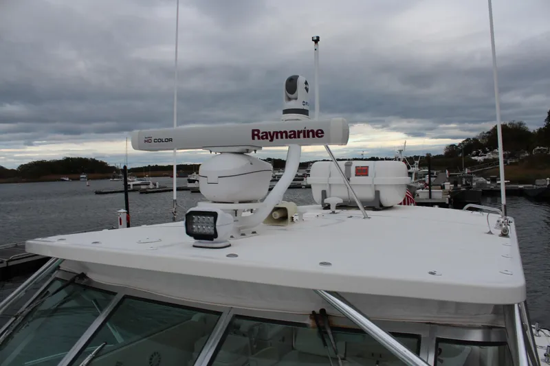 Slide: The Image of 2005 Rampage 38 Express boat with Raymarine radar, docked under cloudy skies. - 10