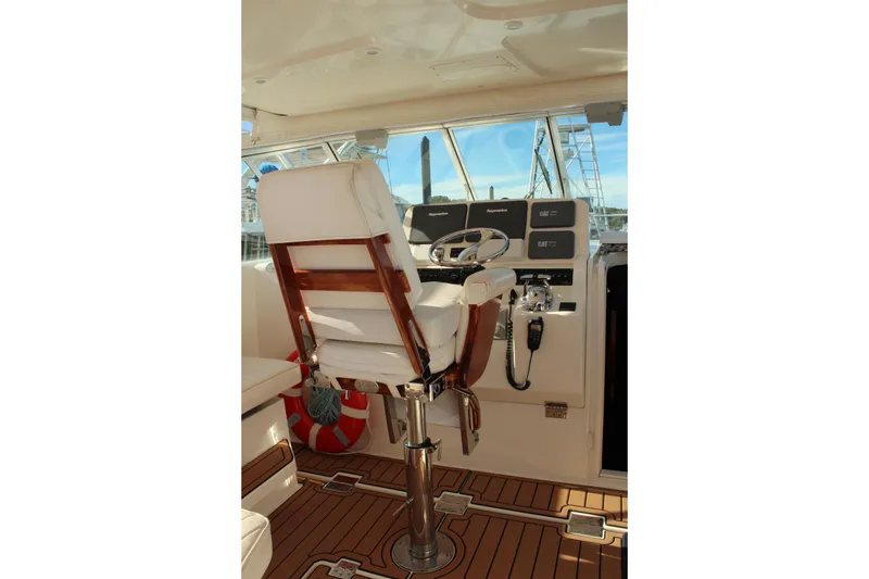Slide: The Image of Captain's chair and helm of 2005 Rampage 38 Express boat, featuring navigation equipment. - 14