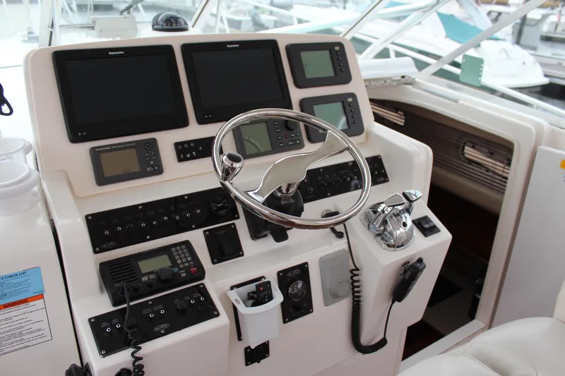 Slide: The Image of Control panel of a 2005 Rampage 38 Express boat with steering wheel and navigation equipment. - 16
