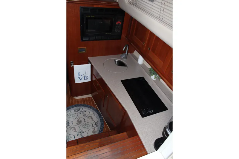 Slide: The Image of 2005 Rampage 38 Express yacht kitchen with stove, sink, and wooden cabinetry. - 24
