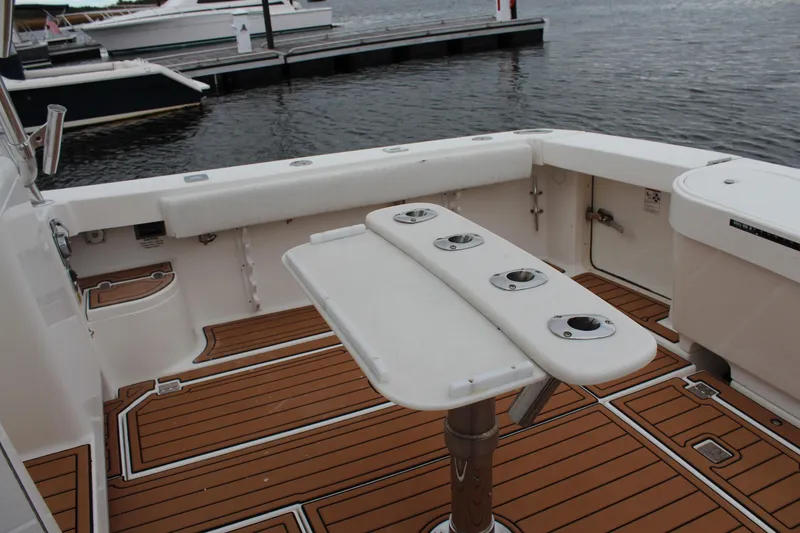 Slide: The Image of 2005 Rampage 38 Express boat deck with rod holders and teak flooring at marina. - 5