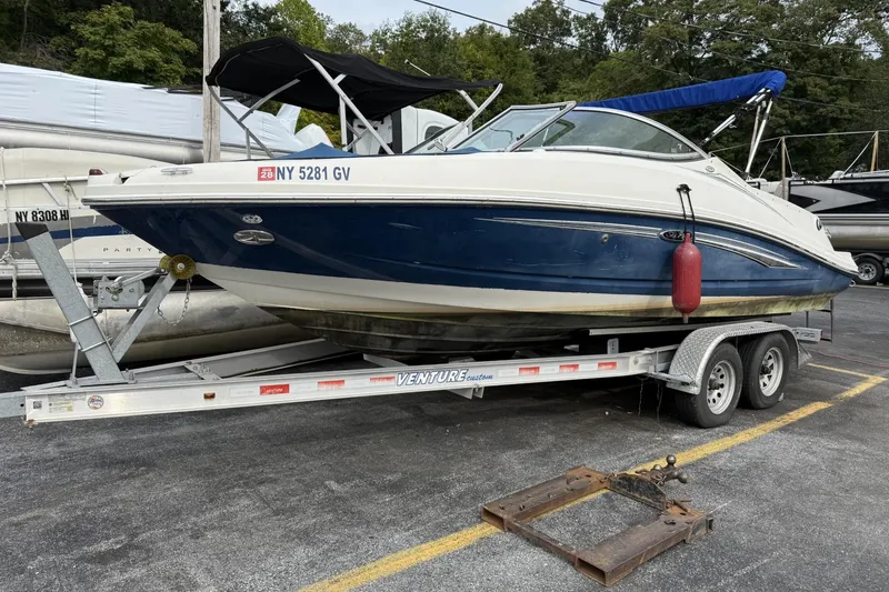 Slide: The Image of 2007 Sea Ray 210 Select boat on trailer, blue and white, parked outdoors. - 4